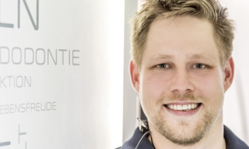 mann mit blonden kurzen haaren lächelt